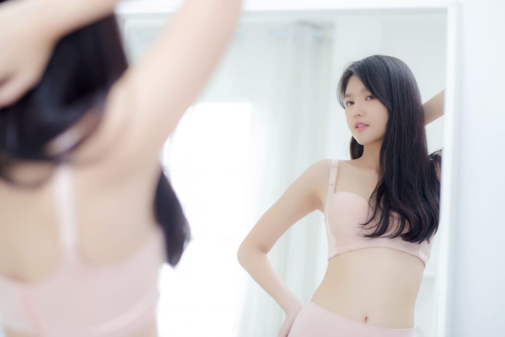 Woman in underwear looking in mirror