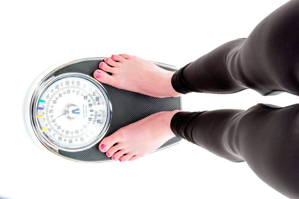 Woman on Scale to lose weight and gain muscle