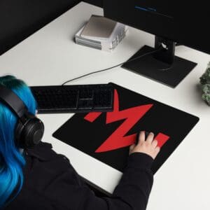 A woman is working at a desk with an MW Gaming mouse pad.