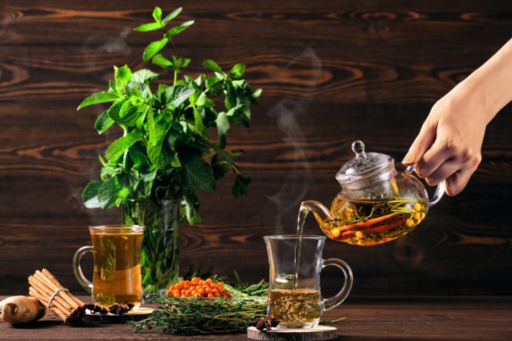 Pouring hot herbal tea with sea buckthorn