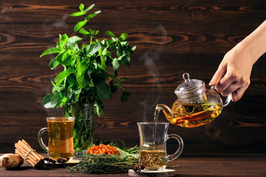 Pouring hot herbal tea with sea buckthorn