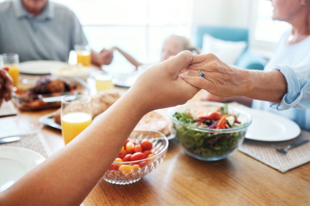 Christian, family and pray for food holding hands for lunch together at home dining table. Faith, g