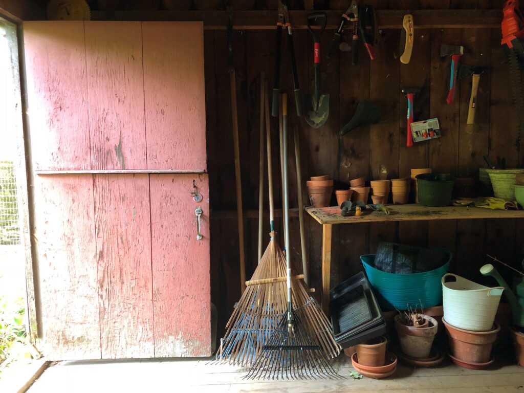 Garden shed with rake, garden tools, and potting bench