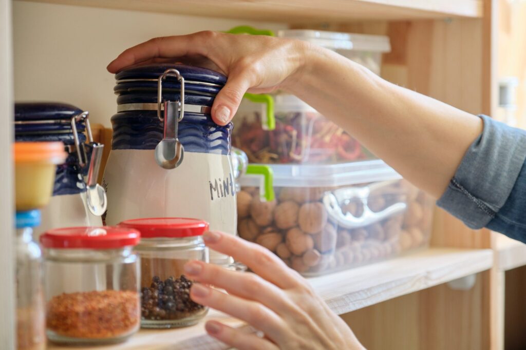 Woman in the kitchen with can of dry mint, food storage, pantry