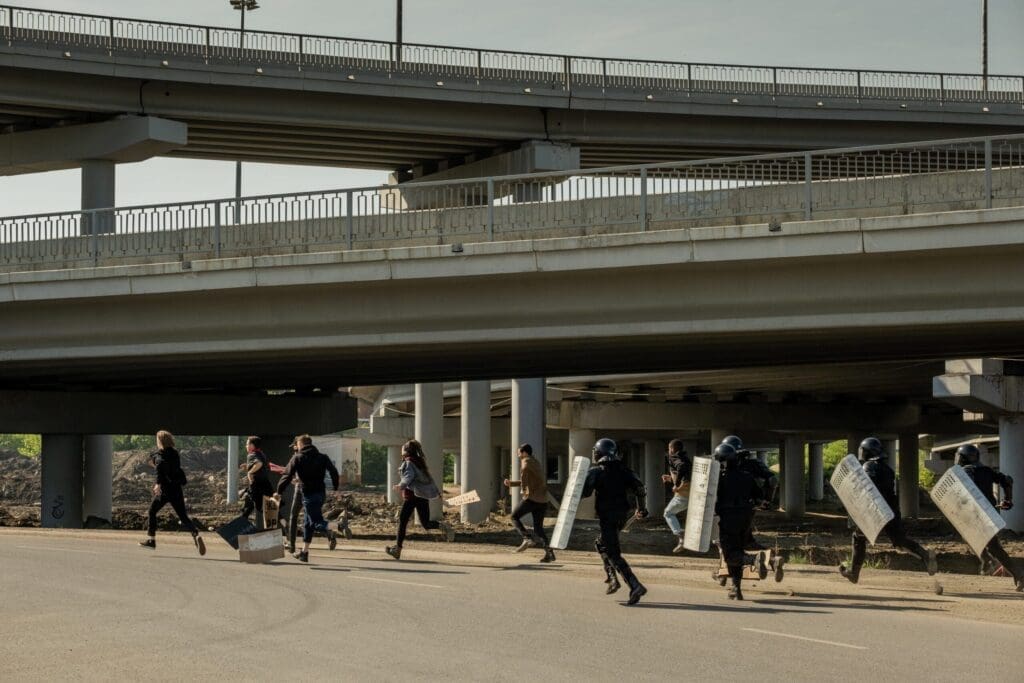 Protestors running from riot police