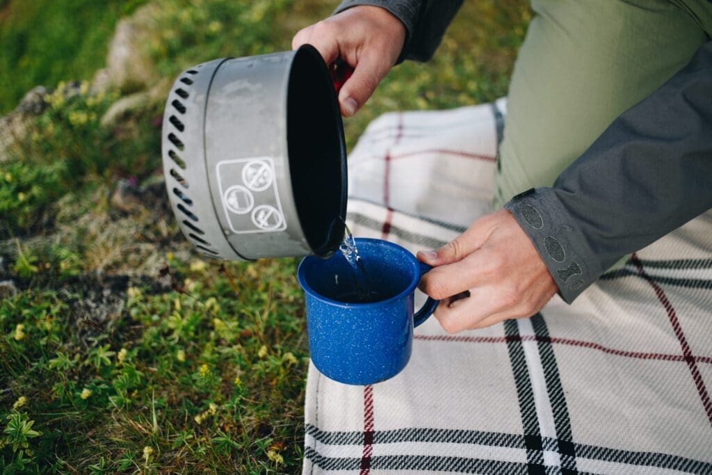 Man pours water from gas camping stove