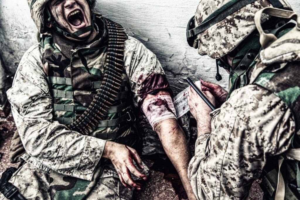Military medic binding gunshot wound during fight