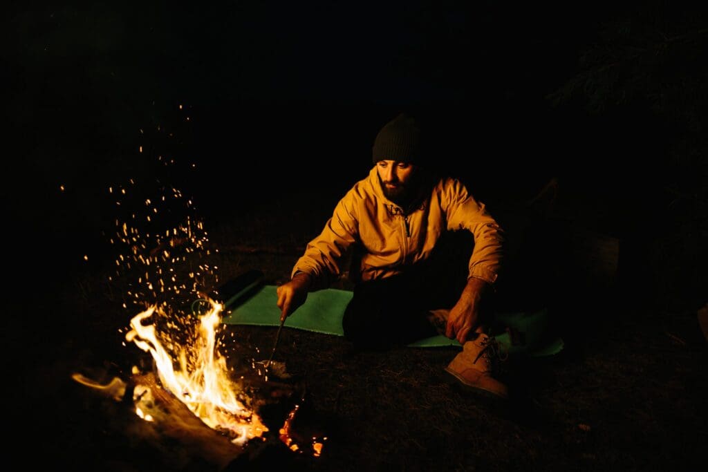 The traveler rests by the night campfire.