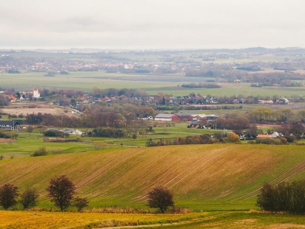 Country landscape with villages, ponds, farms and fields on an autumn day